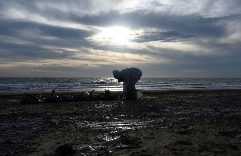 © Reuters. FILE PHOTO: A volunteer works to clear spilled oil on the coastline following an incident involving two tankers damaged in a storm in the Kerch Strait, in the settlement of Blagoveshchenskaya near the Black Sea resort of Anapa in the Krasnodar region, Russia December 21, 2024. REUTERS/Sergey Pivovarov/File Photo