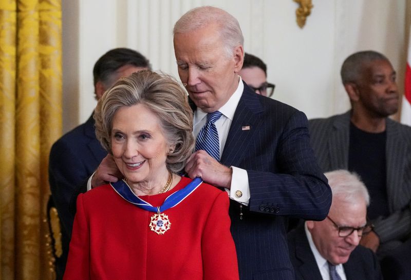 © Reuters. U.S. President Joe Biden presents the Presidential Medal of Freedom to Former U.S. Secretary of State Hillary Clinton, during a ceremony in the East Room of the White House, in Washington, U.S. January 4, 2025. REUTERS/Ken Cedeno