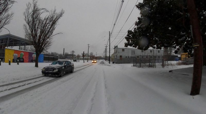 © Reuters. FILE PHOTO: Vehicles drive through the snow as it covers streets in Louisville, Kentucky, U.S., January 5, 2025, in this screen grab obtained from a social media video. Richard Stottman/@cyntrix/via REUTERS/File Photo