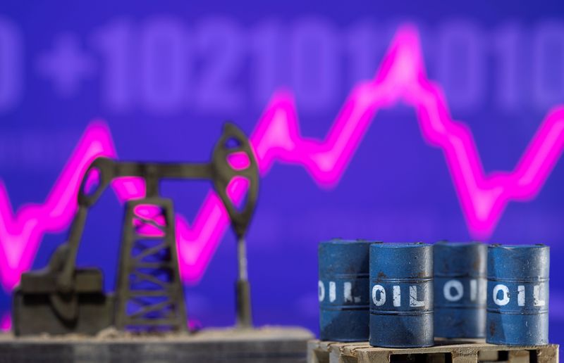 © Reuters. FILE PHOTO: Models of oil barrels and a pump jack are displayed in front of a rising stock graph and