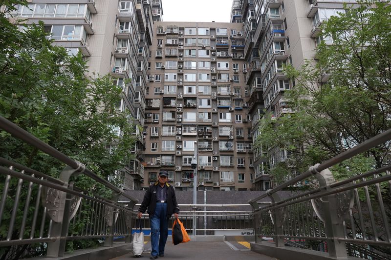 © Reuters. FILE PHOTO: A man walks on a pedestrian bridge near residential buildings in Beijing, China October 17, 2024. REUTERS/Florence Lo/ File Photo