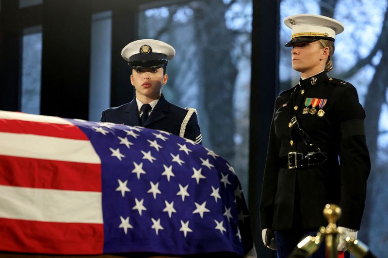 © Reuters. FILE PHOTO: Members of the joint services military honor guard stand next to the casket of former U.S. President Jimmy Carter as he lies in repose at the Jimmy Carter Presidential Library and Museum in Atlanta, Georgia, U.S., January 6, 2025.  Joe Raedle/Pool via REUTERS/File Photo