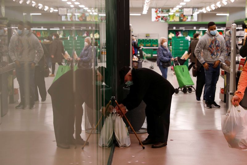 © Reuters. FILE PHOTO: A man prepares to carry bags with groceries after exiting a supermarket in Madrid, Spain, November 29, 2021. REUTERS/Susana Vera/File Photo