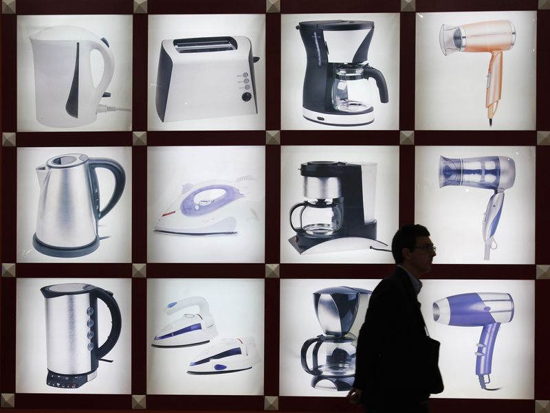 © Reuters. FILE PHOTO: A visitor walks past photos of home electrical appliances at China Import and Export Fair, also known as the Canton Fair, in the southern Chinese city of Guangzhou October 17, 2011. REUTERS/Bobby Yip/ File Photo