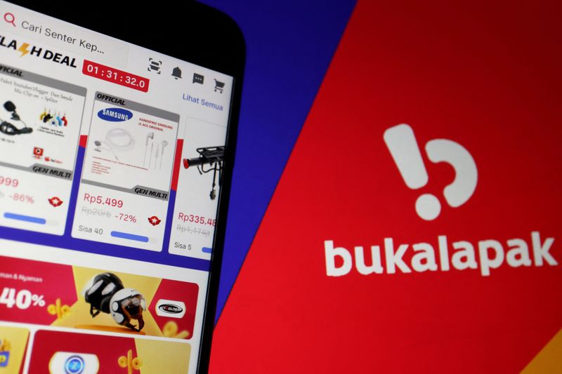 © Reuters. FILE PHOTO: The app of Indonesian e-commerce company Bukalapak is seen on a mobile phone next to its logo displayed in this illustration picture taken July 14, 2021. REUTERS/Florence Lo/Illustration/File Photo