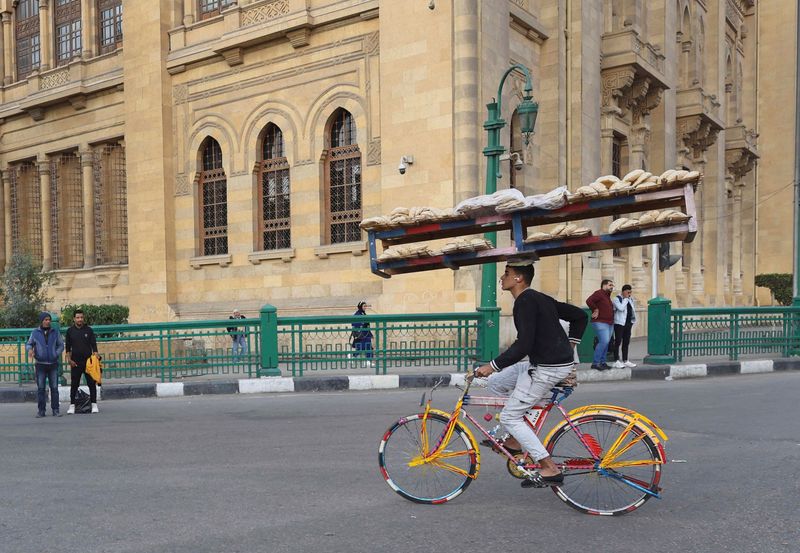 © Reuters. FILE PHOTO: An Egyptian street vendor rides a bicycle as he carries bread on wooden racks in Cairo, Egypt November 12, 2024. REUTERS/Amr Abdallah Dalsh/File Photo