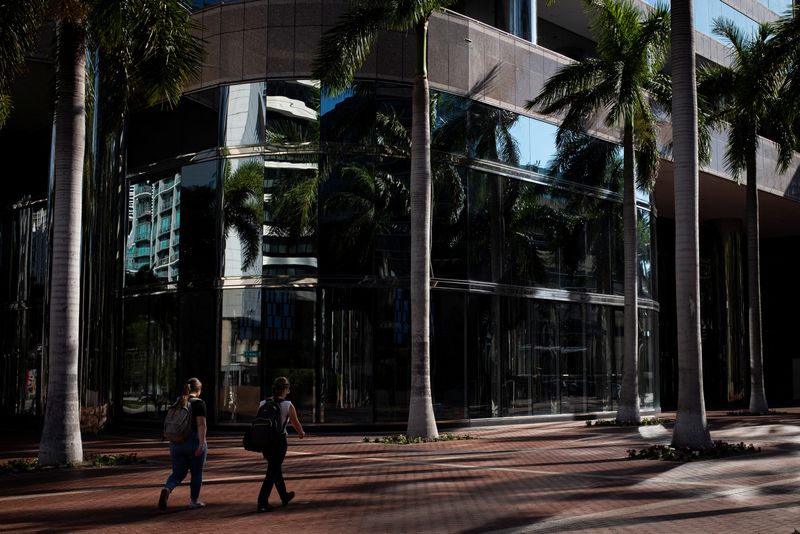 © Reuters. FILE PHOTO: People walk past palm trees in an office building plaza at the Brickell neighborhood, known as the financial district, in Miami, Florida, U.S., February 23, 2023. REUTERS/Marco Bello/File Photo