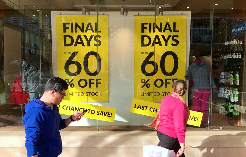 © Reuters. FILE PHOTO: Shoppers walk past sales signs on display in the window of a retail store at a shopping mall in Sydney, Australia, September 4, 2018. REUTERS/David Gray/ File Photo