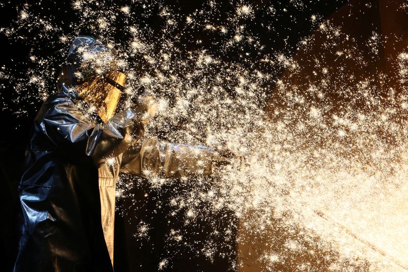 © Reuters. FILE PHOTO: A steel worker of ThyssenKrupp stands amid sparks of raw iron coming from a blast furnace at a ThyssenKrupp steel factory in Duisburg, western Germany, November 14, 2022. REUTERS/Wolfgang Rattay/File photo