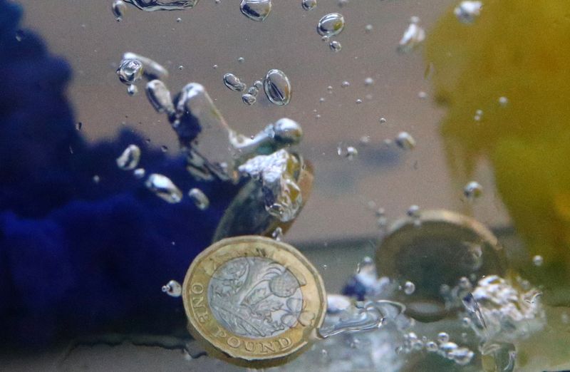 © Reuters. FILE PHOTO: UK pound coins plunge into water coloured with the European Union flag colours in this illustration picture, October 26, 2017. REUTERS/Dado Ruvic/File Photo