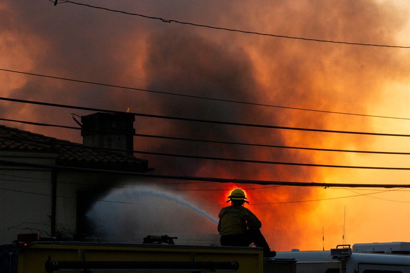 © Reuters. FILE PHOTO: A firefighter battles the Palisades Fire as it burns during a windstorm on the west side of Los Angeles, California, U.S. January 8, 2025. REUTERS/Ringo Chiu/File Photo