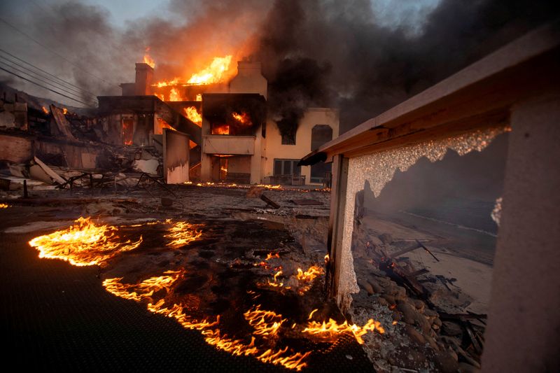 © Reuters. FILE PHOTO: Flames and smoke rise from structures as the Palisades fire burns during a windstorm on the west side of Los Angeles, California, U.S. January 8, 2025. REUTERS/Ringo Chiu/File photo