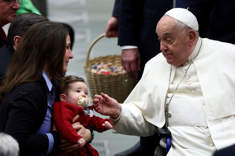 © Reuters. Pope Francis greets a child at the Jubilee audience in Paul VI hall at the Vatican, January 11, 2025. REUTERS/Guglielmo Mangiapane