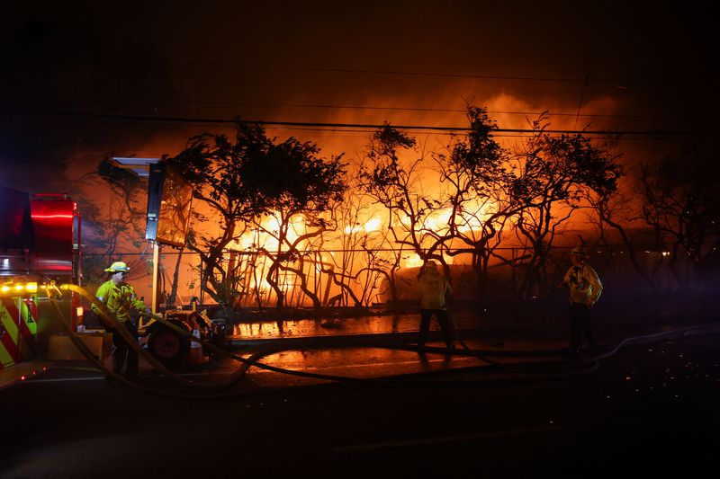 © Reuters. FILE PHOTO: Firefighters work to extinguish flames as the Eaton Fire burns in Pasadena, California, U.S. January 7, 2025. REUTERS/Mario Anzuoni/File Photo