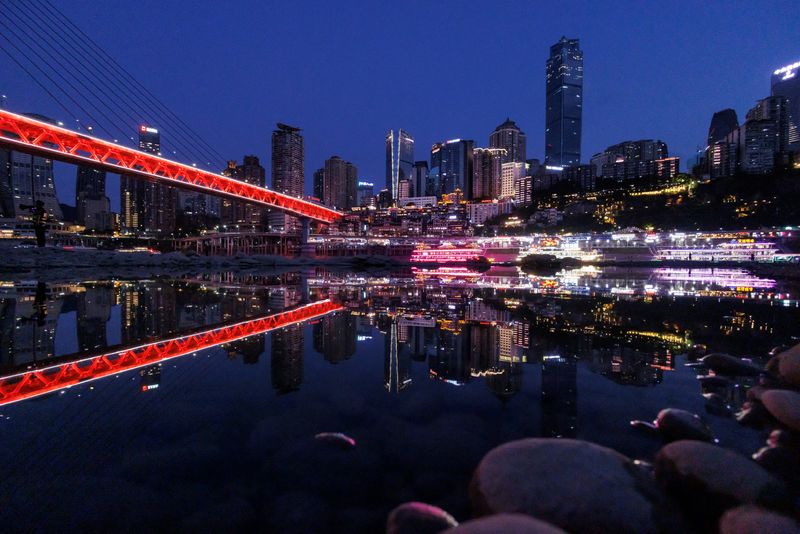 © Reuters. FILE PHOTO: The city skyline is reflected in a pool left on the Jialing river, a tributary of the Yangtze, in Chongqing, China, August 20, 2022. REUTERS/Thomas Peter/File Photo