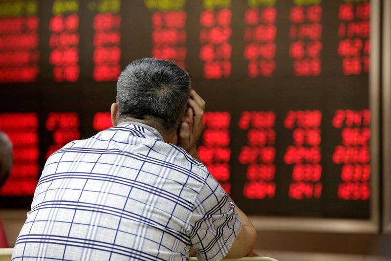 © Reuters. FILE PHOTO: An investor looks at an electronic board showing stock information at a brokerage house in Beijing, China, June 24, 2016. REUTERS/Jason Lee/File Photo