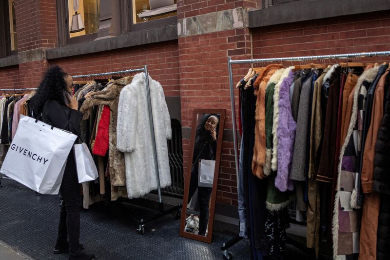 © Reuters. FILE PHOTO: A woman looks at clothes for sale in the Soho area in New York City, U.S., December 30, 2024. REUTERS/Marko Djurica/File Photo