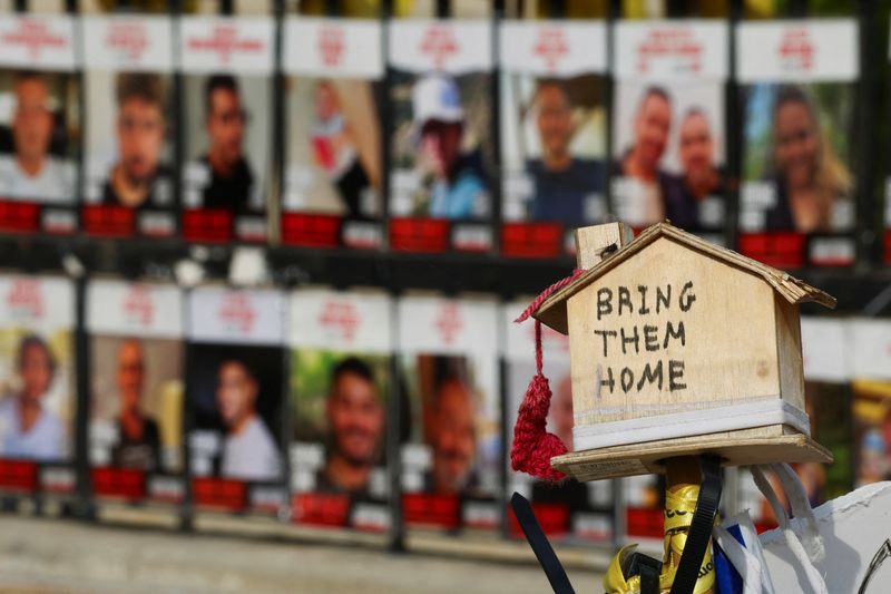 © Reuters. A message in support of the hostages kidnapped during the deadly October 7, 2023 attack by Hamas and who are still held in captivity is seen near photos of hostages, amid the ongoing conflict in Gaza between Israel and Hamas, at the so-called