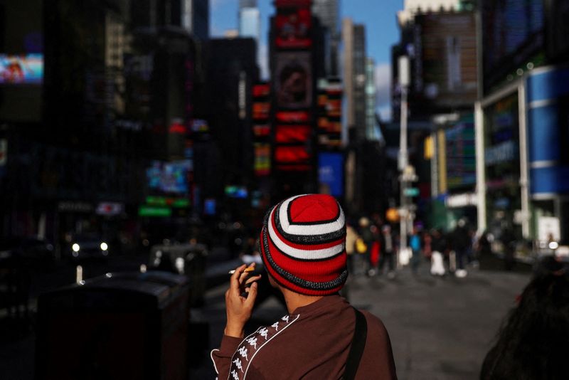 © Reuters. FILE PHOTO: A man smokes a cigarette while sitting in the Times Square section of New York City, U.S., January 18, 2023. REUTERS/Shannon Stapleton/File Photo