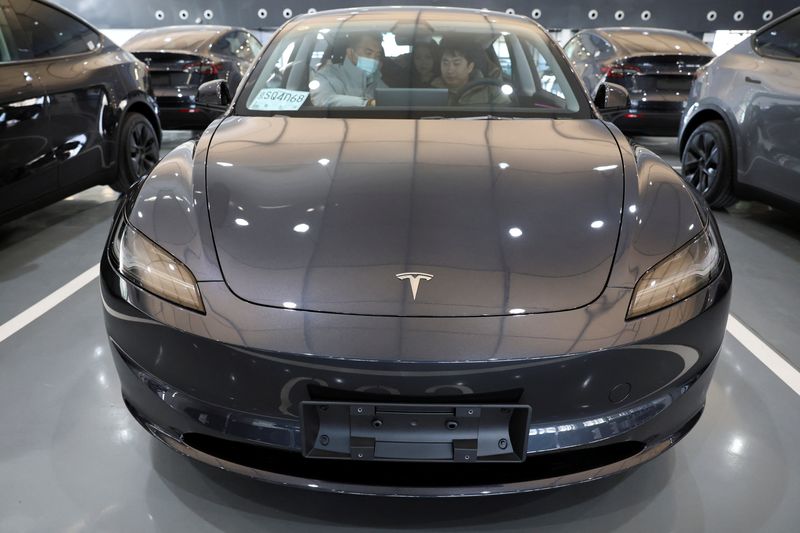 © Reuters. FILE PHOTO: Customers sit in a Tesla Model Y electric vehicle (EV) at the carmaker's delivery centre in Beijing, China January 8, 2025. REUTERS/Florence Lo/File Photo