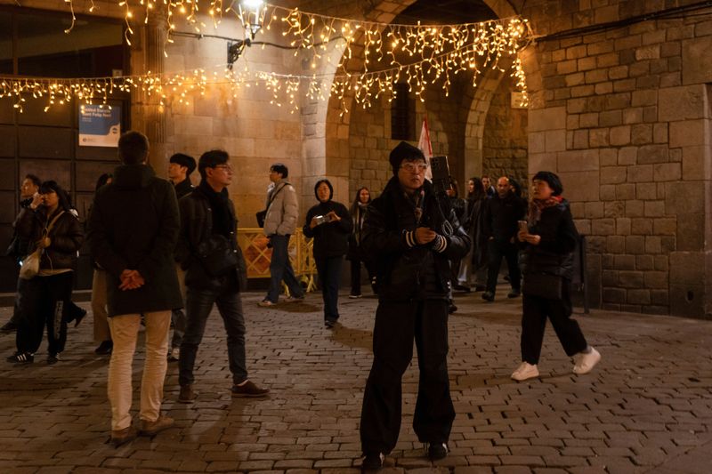 © Reuters. FILE PHOTO: A tourist takes a photo of  the Christmas lights in the Born neighborhood in Barcelona, Spain January 3, 2025. REUTERS/Bruna Casas/File Photo