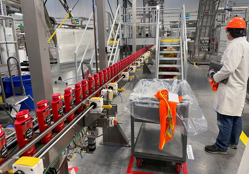 © Reuters. FILE PHOTO: A person works with robots at Procter & Gamble's factory in Tabler Station, West Virginia, U.S., May 28, 2021. Picture taken May 28, 2021. REUTERS/Timothy Aeppel/File Photo