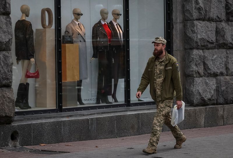 © Reuters. FILE PHOTO: A Ukrainian serviceman walks by a shop window with mannequins, amid Russia's attack on Ukraine, in central Kyiv, Ukraine October 26, 2023. REUTERS/Gleb Garanich/File Photo