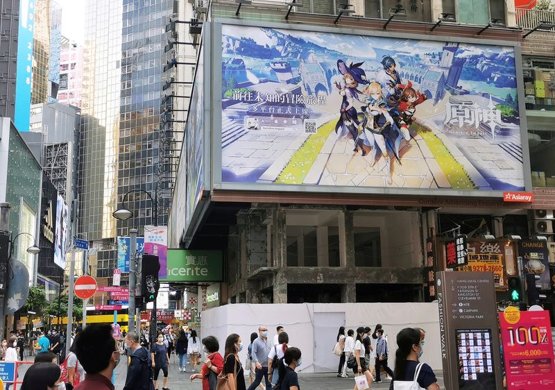 © Reuters. FILE PHOTO: People walk below a billboard ad of fantasy game