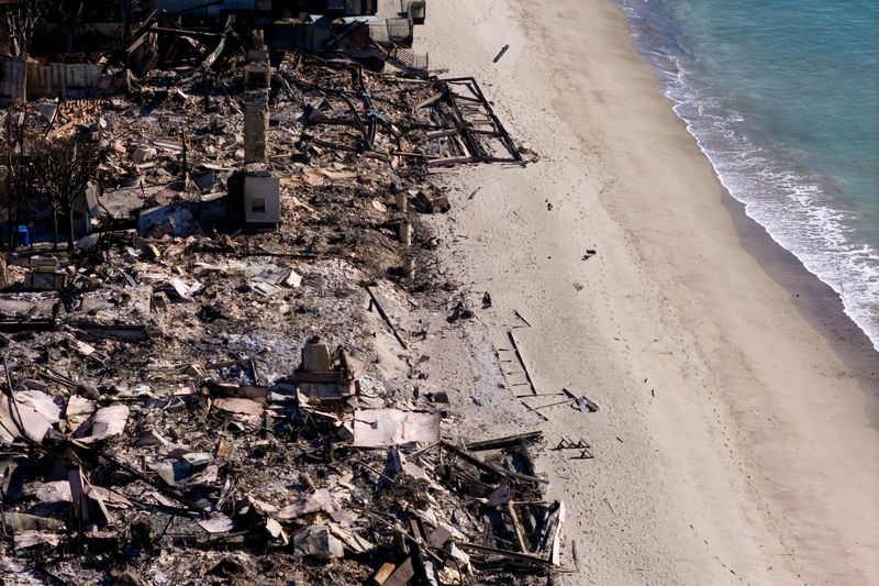 © Reuters. FILE PHOTO: A drone view shows a site where beachfront houses were burnt down by the Palisades Fire, in Malibu, California, U.S., January 16, 2025. REUTERS/Mike Blake/File Photo