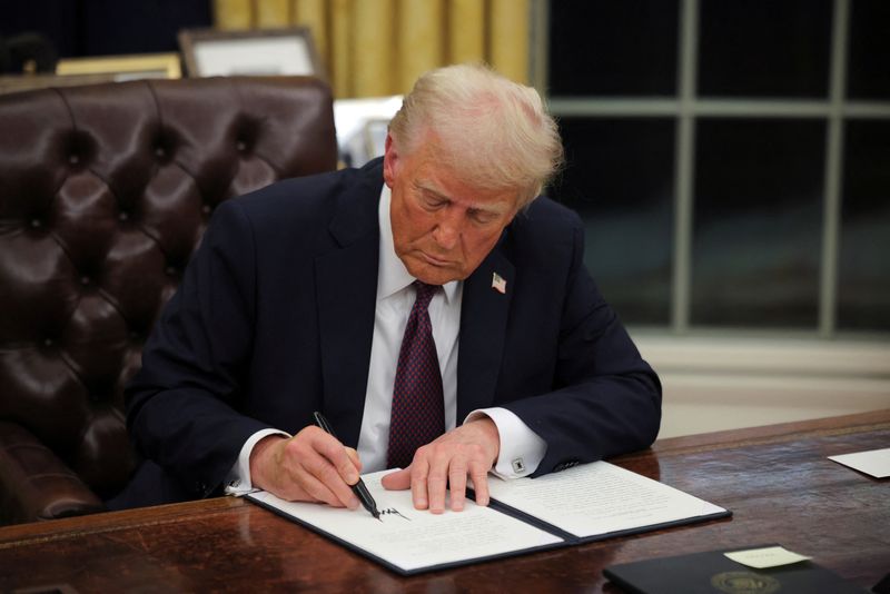 © Reuters. U.S. President Donald Trump signs documents as he issues executive orders and pardons for January 6 defendants in the Oval Office at the White House on Inauguration Day in Washington, U.S., January 20, 2025.  REUTERS/Carlos Barria