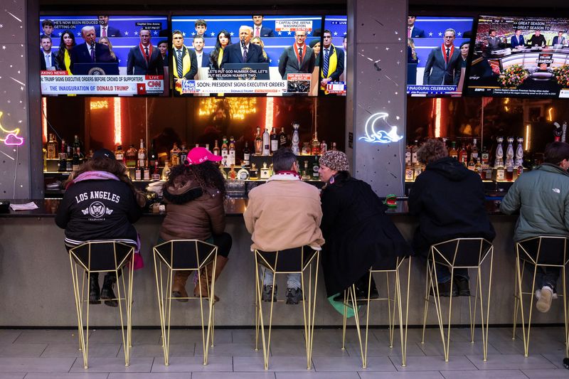 © Reuters. People sit at a bar near the Capital One Arena during ceremonies on the inauguration day of U.S. President Donald Trump second presidential term, in Washington, U.S. January 20, 2025. REUTERS/Marko Djurica