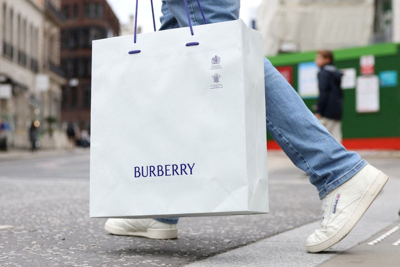 © Reuters. FILE PHOTO: A man carries a Burberry shopping bag on New Bond Street in London, Britain, July 15, 2024. REUTERS/Hollie Adams/File Photo