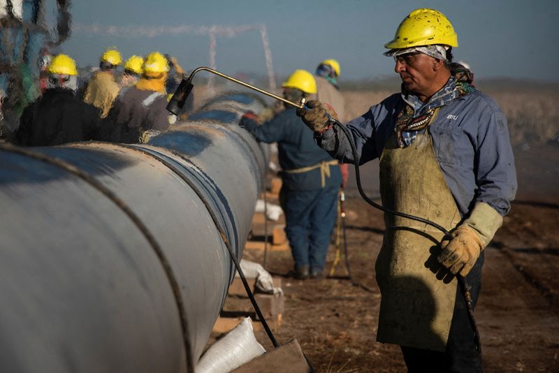 © Reuters. FILE PHOTO: People work during the construction of the Nestor Kirchner gas pipeline in Macachin, La Pampa, Argentina April 26, 2023. REUTERS/Martin Cossarini/File Photo