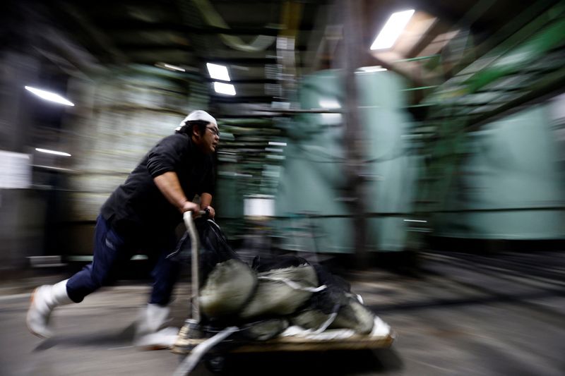 © Reuters. FILE PHOTO: A brewer runs as he delivers bags of steamed rice on a trolly to his co-workers at Ishikawa Shuzou, or Ishikawa Brewery, in Fussa, western Tokyo, Japan November 25, 2024.  REUTERS/Issei Kato/File Photo