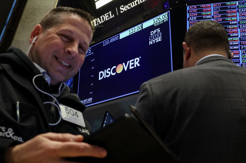 © Reuters. FILE PHOTO: A screen displays the logo and trading information for  Discover Financial as traders work on the floor at the New York Stock Exchange (NYSE) in New York City, U.S., February 20, 2024.  REUTERS/Brendan McDermid/File Photo