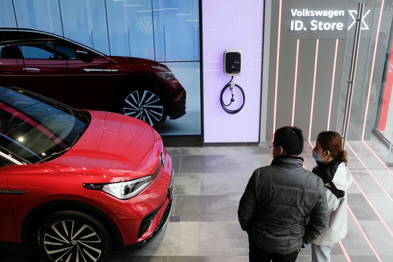 © Reuters. FILE PHOTO: People check a Volkswagen ID.4 X electric vehicle displayed inside a showroom in Chengdu, Sichuan province, China January 10, 2021. Picture taken January 10, 2021. REUTERS/Yilei Sun/File Photo