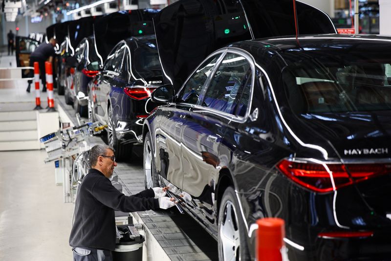 © Reuters. FILE PHOTO: A worker attaches a part to a Mercedes-Maybach car on a production line of