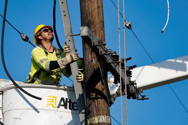 © Reuters. FILE PHOTO: An L.A. Department of Water and Power electrical worker installs hardware to support power lines following the Palisades Fire, in Pacific Palisades, California, U.S., January 17, 2025. REUTERS/Fred Greaves/File Photo