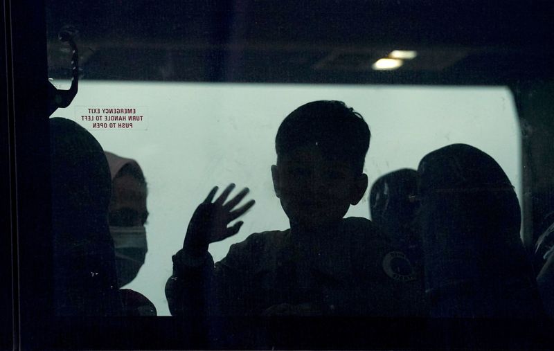 © Reuters. FILE PHOTO: An Afghan boy waves from a bus taking refugees to a processing center upon their arrival at Dulles International Airport in Dulles, Virginia, U.S.,  September 1, 2021. REUTERS/Kevin Lamarque/File Photo