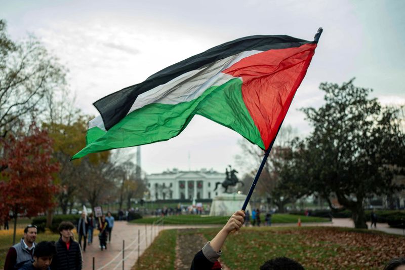 © Reuters. FILE PHOTO: A person waves a Palestine flag at Lafayette Square during a pro-Palestinian demonstration near the White House in Washington, U.S., December 2, 2023. REUTERS/Bonnie Cash/File Photo