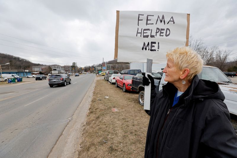 © Reuters. FILE PHOTO: Swannanoa resident Lucy Bickers, who received assistance from FEMA after Hurricane Helene damaged her property, holds a sign in support of the government agency as she waits on the route of visiting U.S. President Donald Trump's motorcade in Swannanoa, North Carolina, U.S., January 24, 2025/File Photo