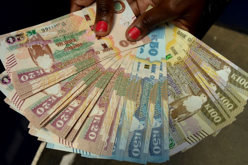 © Reuters. FILE PHOTO: A woman displays a selection of Kwacha notes, the national currency and money used in Zambia in Lusaka, Zambia February 27, 2024. REUTERS/Namukolo Siyumbwa/File Photo