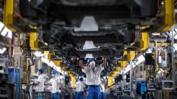 Employees wearing masks work on a car assembly line at the SAIC General Motors Co. The SAIC General Motors Wuhan Branch has resumed production following epidemic prevention and control rules. The SAIC General Motors Wuhan Branch temporarily halted production because of the suspension of supply chains as Shanghai locked down. China car sales plunged the most in two years in April as Covid-19 lockdowns in the auto industry hubs of Shanghai and Jilin province smashed production and kept buyers out of showrooms.