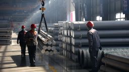 This picture taken on February 25, 2025 shows workers transporting aluminium rods at an aluminium-base material factory in Binzhou, in eastern China's Shandong province.